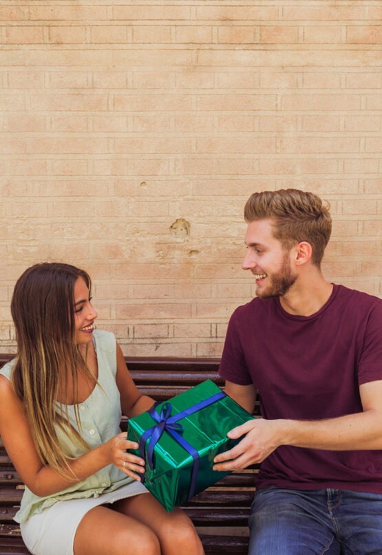 woman is happy while giving the gift to her boyfriend
